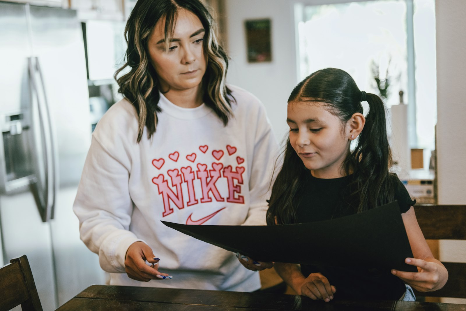 a woman standing next to a little girl in a kitchen Raising a child who takes initiative