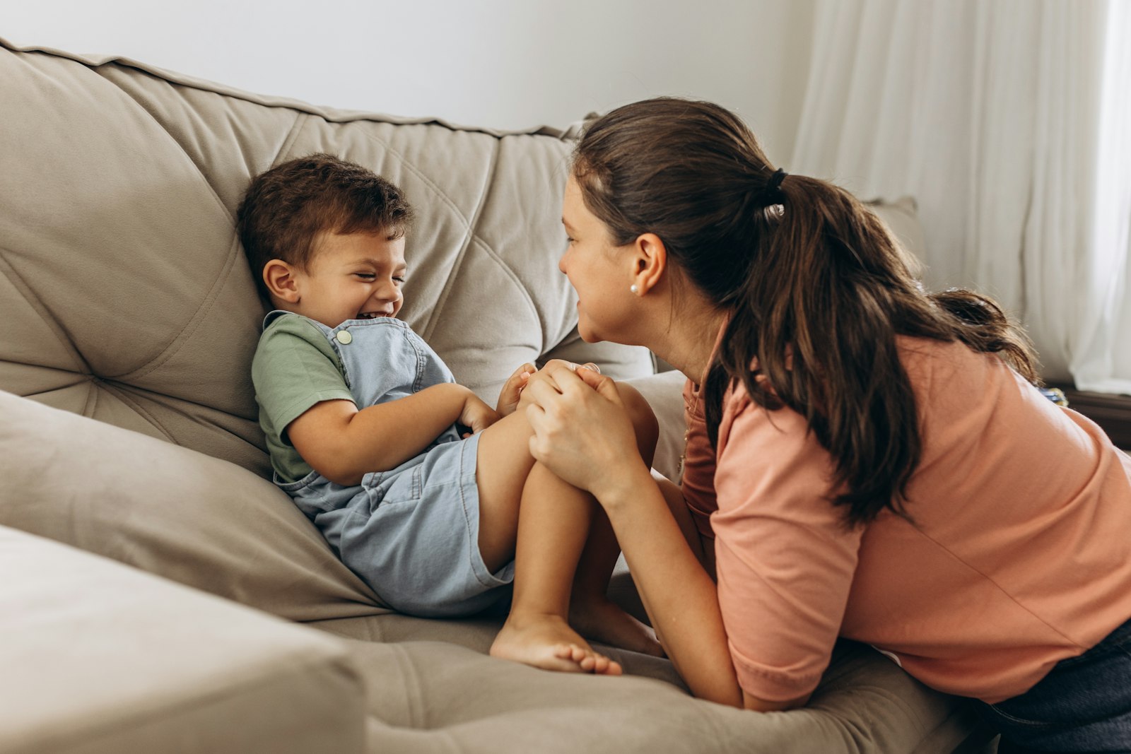 a woman sitting on top of a couch next to a little boy Why gentle parenting isn't working