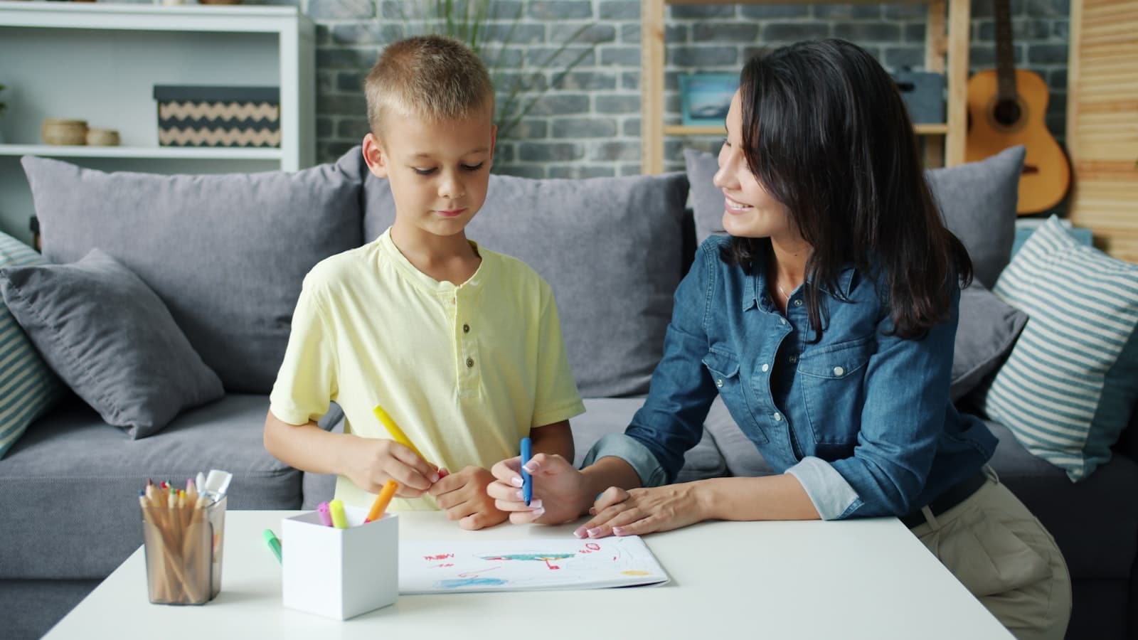 Mother and son drawing together at a table. Teaching kids about risk and decision making