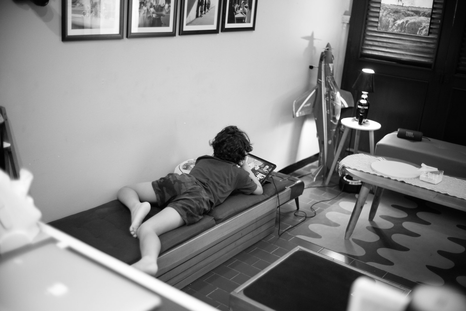 Child lying on a daybed looking at a tablet. design choices